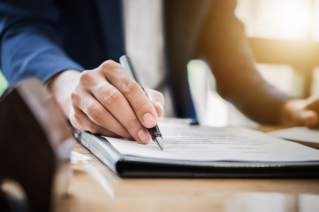 woman holding pen and reviewing loan document