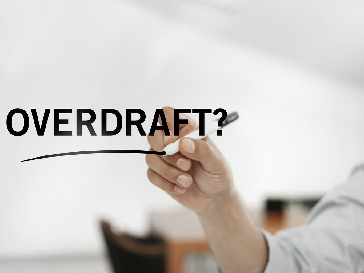 businessman writing on a virtual board quoting “Overdraft?”